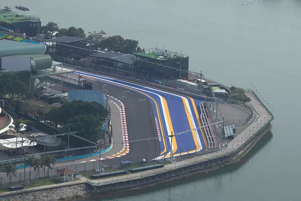 Imagem colorida de pista de corrida da Formula 1 do GP de Singapura vista de cima, tempo nublado, lado direito há um lago - Metrópoles