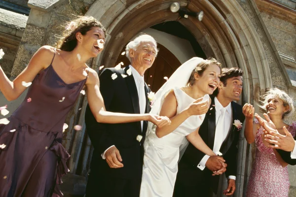 Noivos sorrindo em casamento com familiares ao redor - Metrópoles