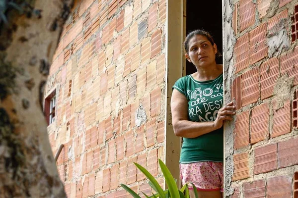Lucimar Pereira Neves, 39 anos, na porta de sua casa, em Abadiânia (GO), onde caseiro suspeito de três homicídios é procurado