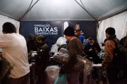 Pessoa em situação de rua pega doação em tenda da Operação Baixas Temperaturas