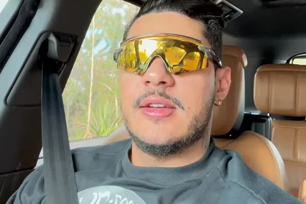 Imagem colorida do cantor Hungria usando um óculos amarelo