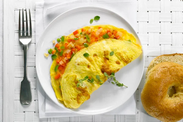 Foto colorida de omelete com legumes em um prato branco - Metrópoles