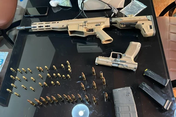 Imagem colorida de Arma e munições apreendidas em operação policial. Metrópoles