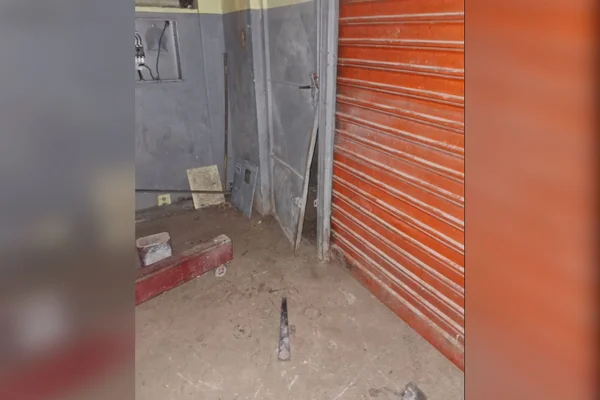 Imagem colorida de uma porta arrombada em uma oficina - Metrópoles