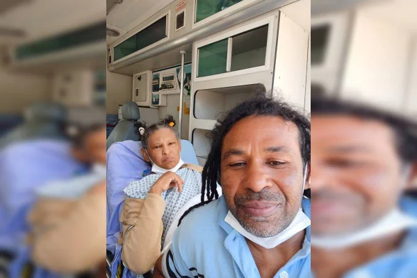 Esposa e marido com roupa azul dentro de ambulância