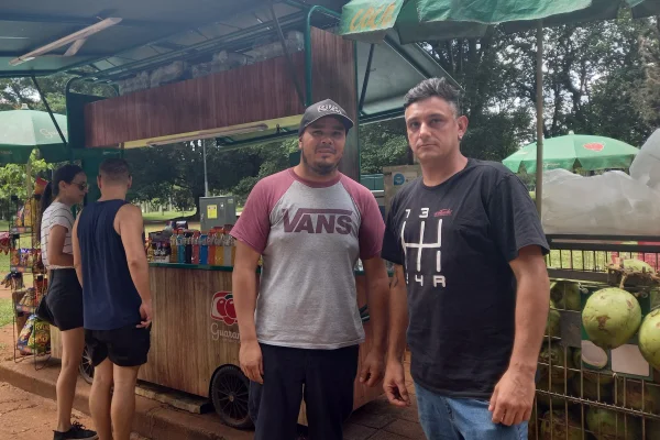 Imagem mostra homens em frente a carrinho de coco - Metrópoles