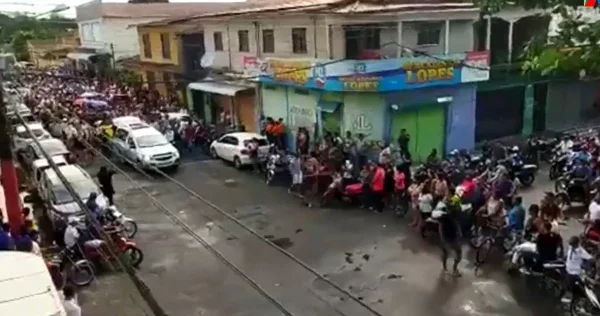 print de um vídeo em que um carro funeráio passa por uma avenida cheia de pessoas