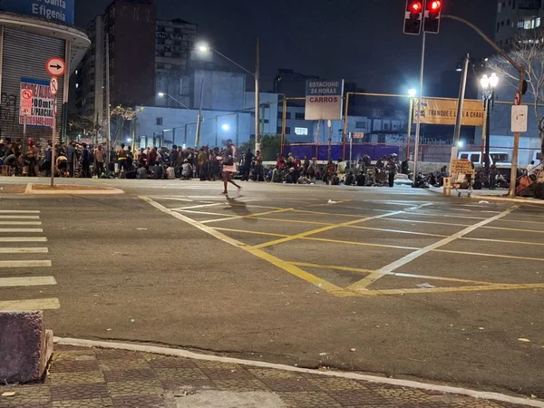 Imagem mostra concentração de pessoas em esquina durante o período noturno