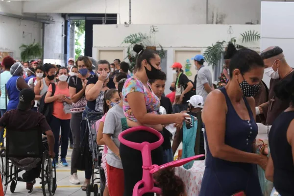 Imagem colorida mostra multidão em fila - metrópoles