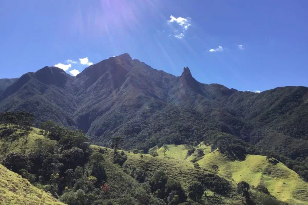 Imagem colorida de montanhas verdes e céu azul - Metrópoles