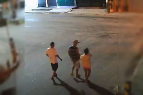 Imagem colorida de homens acompanhando mulher na rua