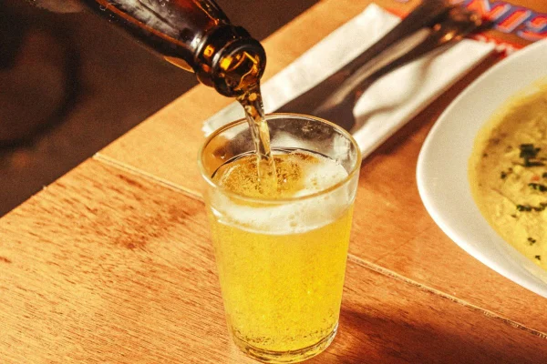 Imagem colorida, uma garrafa de cerveja e um copo cheio - Metrópoles