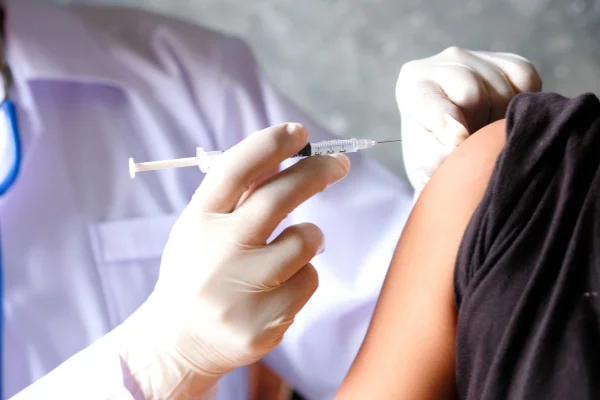 A mão do médico usa seringas para prevenir vírus. Injeção em criança ou mulher. Conceito de vacinação ou anticoncepcional injetável. Metrópoles vacinas