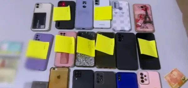 Imagens de vários celulares espalhados sobre uma mesa, com post-its colados - Metrópoles