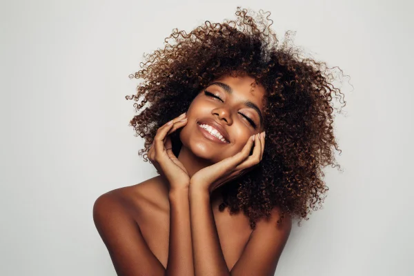 Mulher de pele preta com a mão no rosto