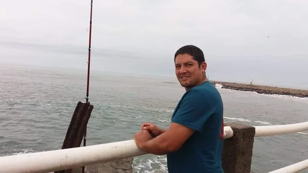 foto de homem na beira de um rio sorrindo para foto