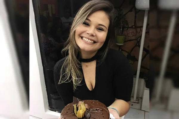Jovem branca, com cabelo longo, sorrindo
