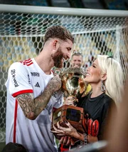 Karoline Lima e Léo Pereira posam juntos no campo após vitória do Flamengo
