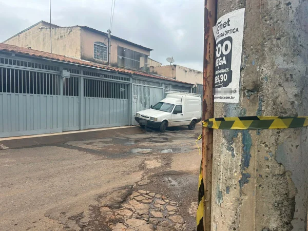 Casa com portão cinza e carro parado na frente