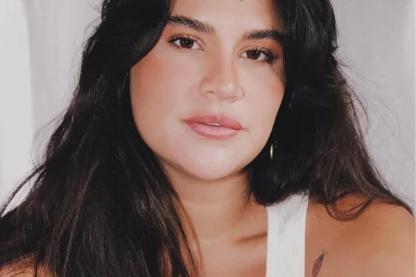 foto em formato selfie da influenciadora e atriz Giulia Costa, olhando diretamente para a câmera, com uma blusa branca