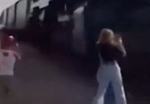 Imagem colorida de mulher quase atingida por trem - Metrópoles