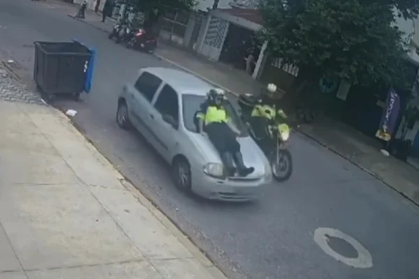 Agente de trânsito se agarra a capô de carro para não ser atropelada