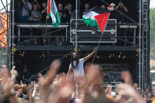 Imagem colorida de homem segurando bandeira da palestina