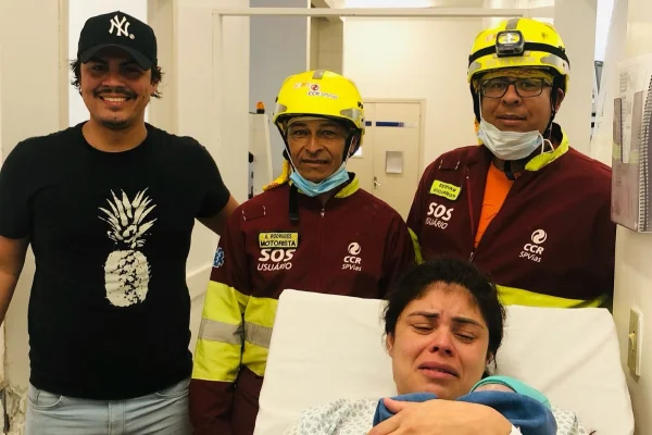 Imagem colorida de socorristas e família socorrida. Metrópoles