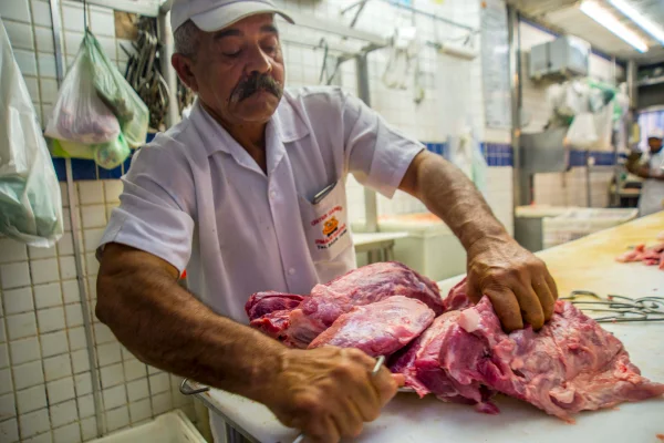 Imagem colorida de açougueiro em supermercado