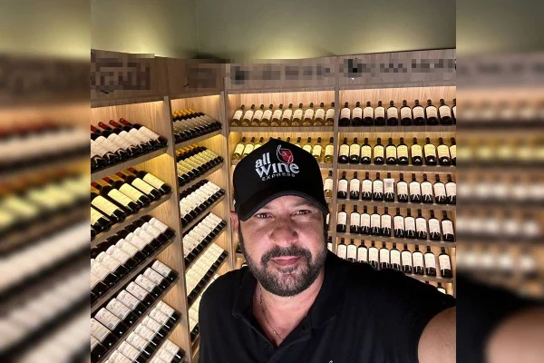 homem de boné atrás de vinhos