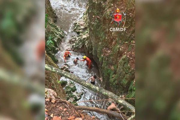 Bombeiros resgatando pessoas de córrego cheio