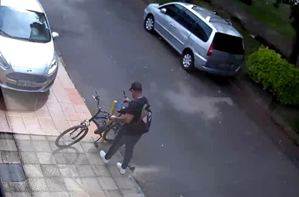 Imagem colorida de homem furtando bicicletas