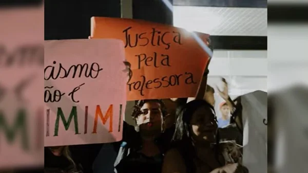 foto colorida de alunos segurando cartazes em protesto antirracista