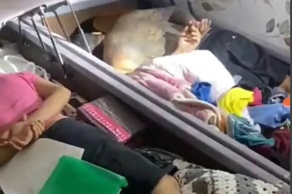 Em foto colorida dois homens deitados dentro de baú de cama box - Metrópoles