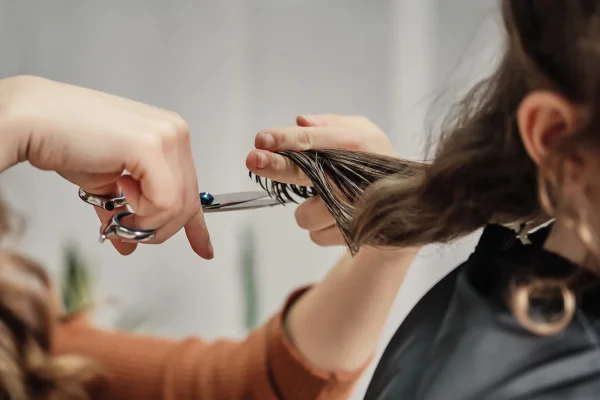 Cabelo de mãos humanas cortado usando uma mecha de cabelo em tesoura