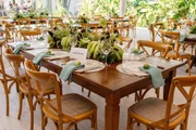 Mesas adornadas com arranjos naturais e penca de bananas