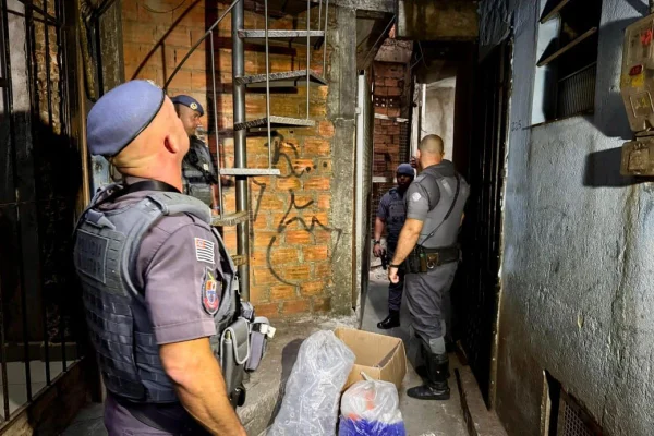 Imagem colorida de dois policiais adentrando a habitação - Metrópoles