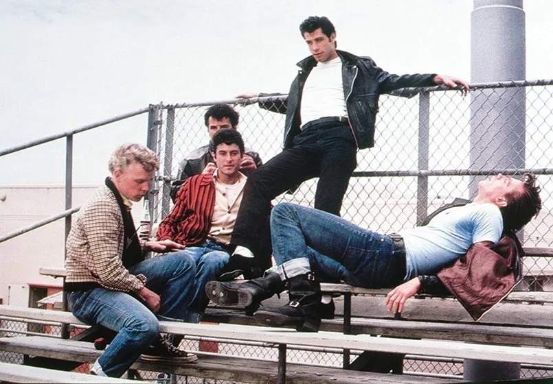 <strong>Grease – Nos Tempos da Brilhantina (1978).</strong> No longa, Sandy (Olivia Newton-John) e o "greaser" Danny (John Travolta) se apaixonam durante o verão. Surpreendentemente, ao mudar de escolas, Sandy reencontra seu amor. As músicas são cantadas pelos atores, mostrando a cultura dos anos 1950, que quebrava os moldes da sociedade tal como o rock faz há décadas. Assista ao <a href="https://youtu.be/f2CCEixOVVU">trailer</a> <strong>Grease – Nos Tempos da Brilhantina (1978).</strong> No longa, Sandy (Olivia Newton-John) e o "greaser" Danny (John Travolta) se apaixonam durante o verão. Surpreendentemente, ao mudar de escolas, Sandy reencontra seu amor. As músicas são cantadas pelos atores, mostrando a cultura dos anos 1950, que quebrava os moldes da sociedade tal como o rock faz há décadas. Assista ao <a href="https://youtu.be/f2CCEixOVVU">trailer</a>