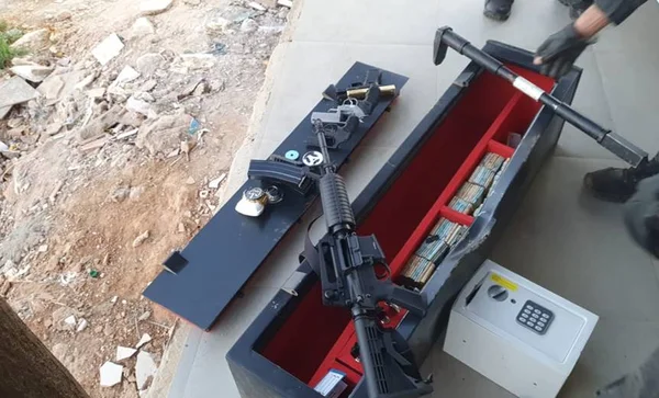 foto colorida de fuzil, pistola, revólveres e dinheiro