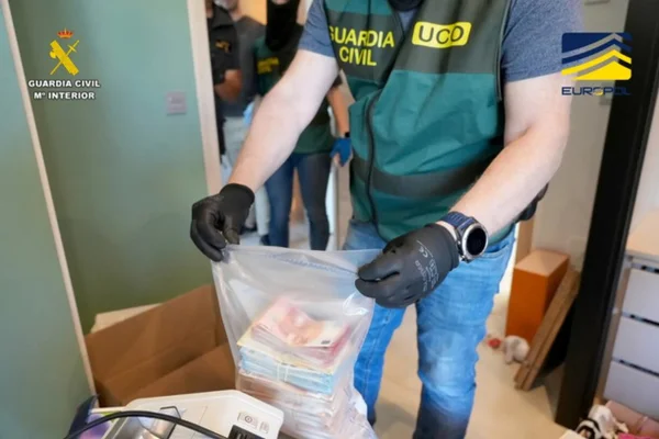Foto colorida de agente apreendendo dinheiro em espécie - Metrópoles