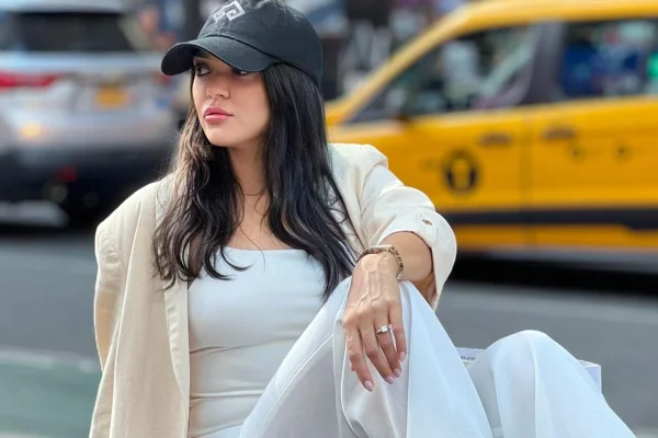 Luciane Vaz posa de look claro e boné preto - Metrópoles