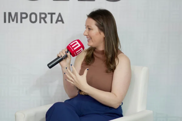 Fotografia colorida mostrando mulher sentada falando em microfone-Metrópoles