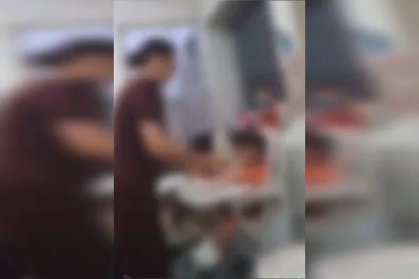 Foto colorida da suposta dona creche agredinda uma criança no Guará, após forçar a menina a comer