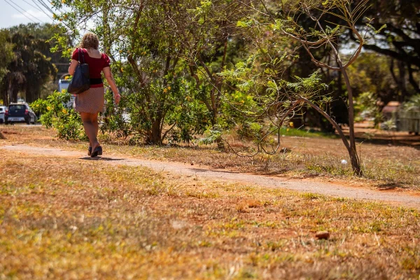 Mulher andando em meio a vegetação típica do cerrado brasiliense