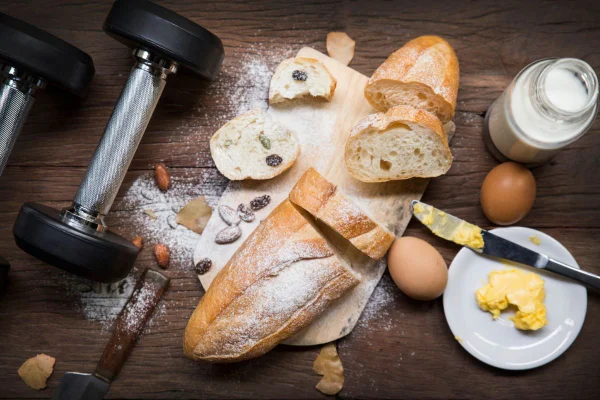 pesos de uma academia ao lado de uma tábua com pães