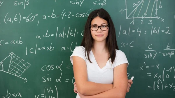 Mulher em frente a um quadro com contas de matemática