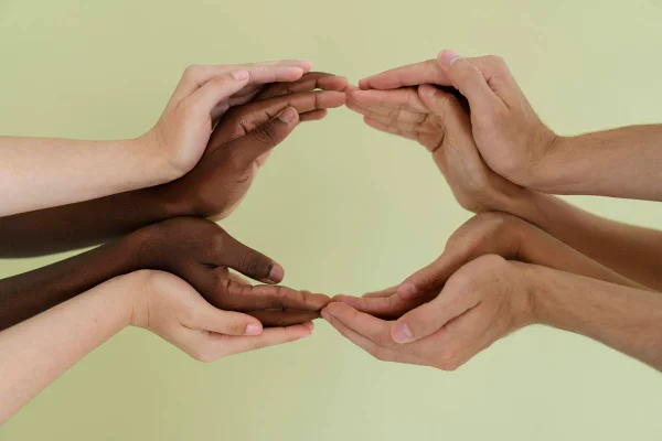 Foto colorida de várias mãos entrelaçadas - Metrópoles