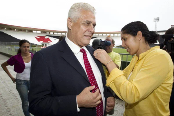 Roberto Dinamite rebendo ajuda da presidente de futebol feminino Steffi Jones em detalhe na roupa