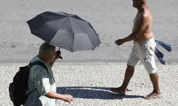imagem colorida homens andando sob sol forte rio de janeiro