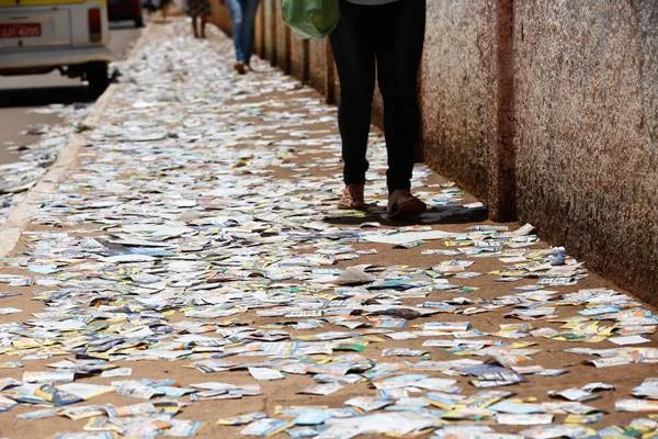 Fotografia colorida de santinhos jogados em calçada